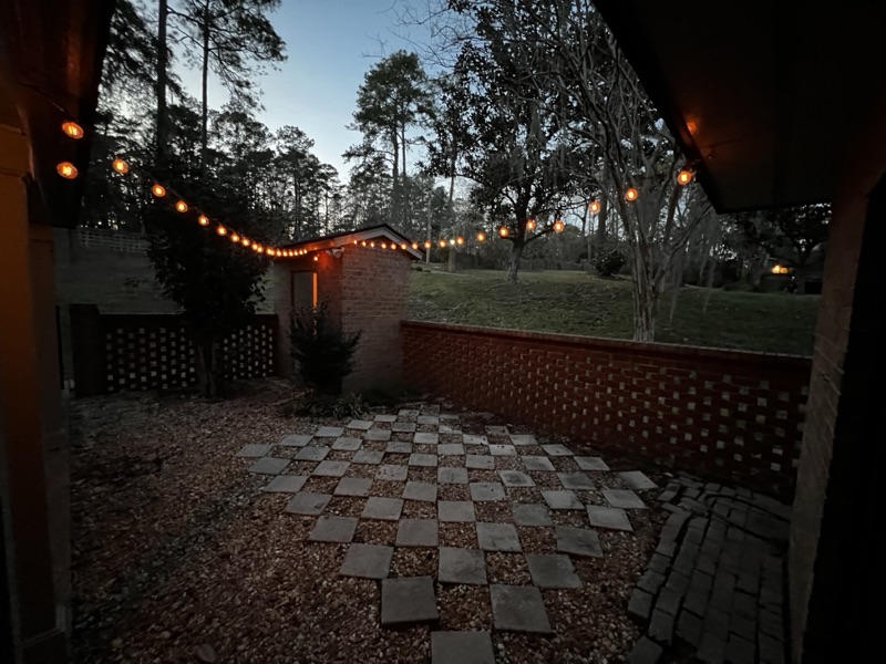 Outdoor patio with brick pavers and string lighting
